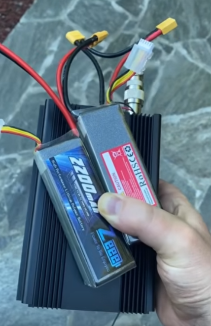 QRO20 transceiver held next to its 4S LiPo battery pack